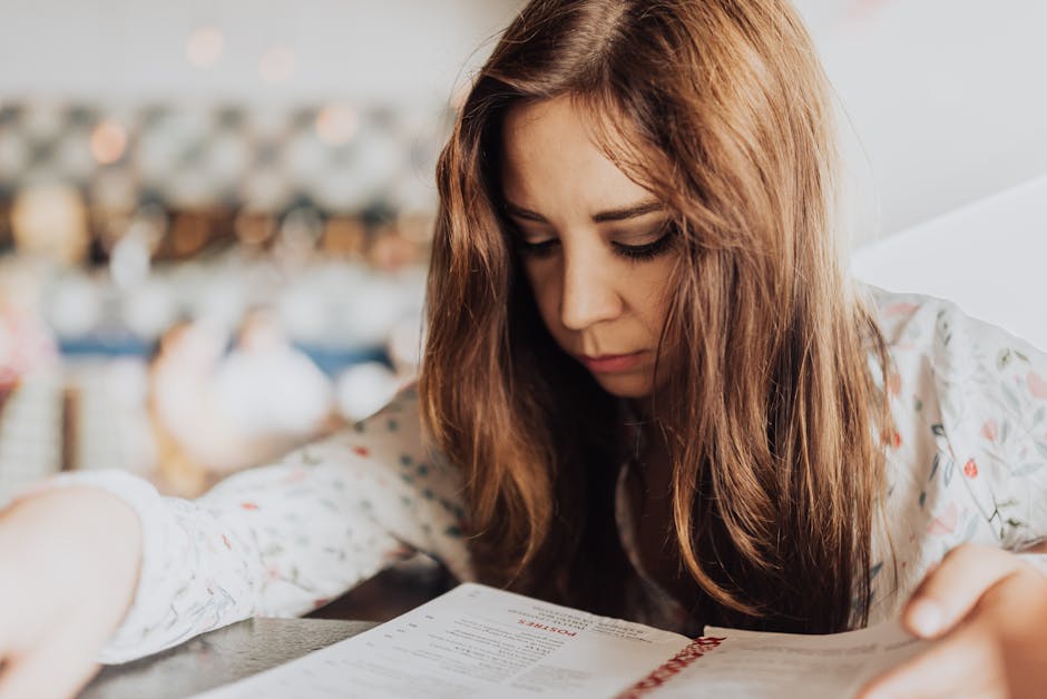 Young woman intensely focused on reading a menu inside a café, creating an introspective and cozy atmosphere.
