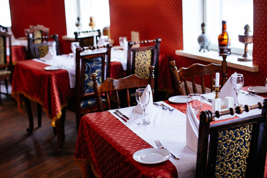 Lavishly set dining tables with elegant cutlery and rich decor in a classic restaurant setting